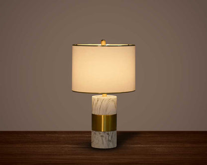 this table lamp in gold plated metal & marble base. It comes with a round translucent fabric shade in modern chic design.