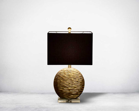 Table lamp in gold decorative glass base on a silver-plated metal stands with black fabric translucent fabric shade front view