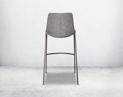 this wooden bar stool back with is a striking mix of industrial and modern. The supple seat, upholstered in fabric sits atop a stainless steel base in wood finish.