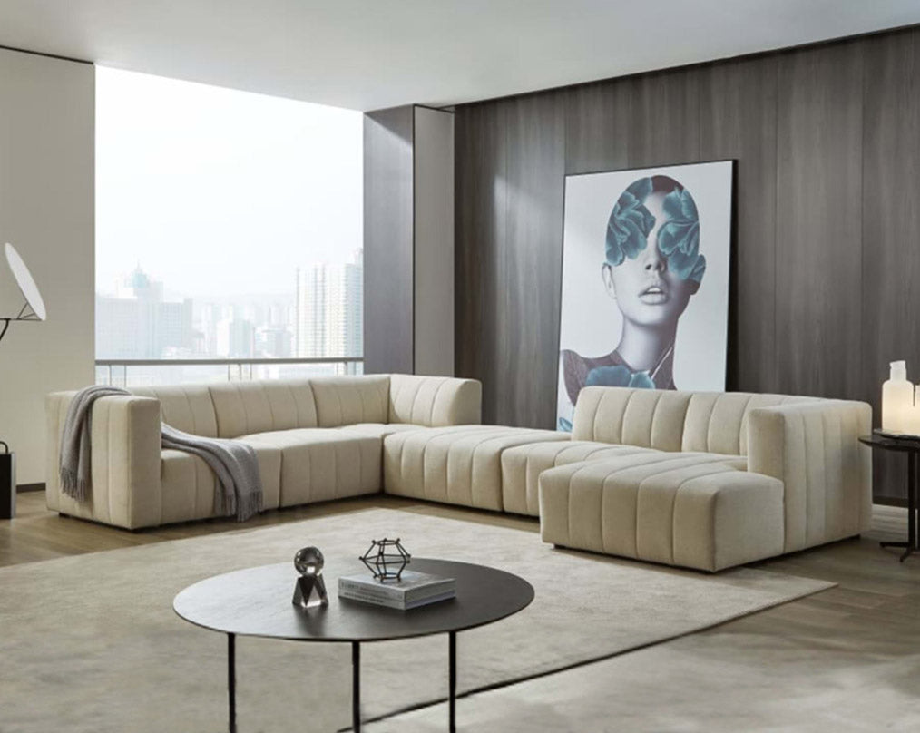 The L shaped modular sofa comes upholstered in regal beige fabric with vertical channel quilting & an ottoman to compliment with living room.