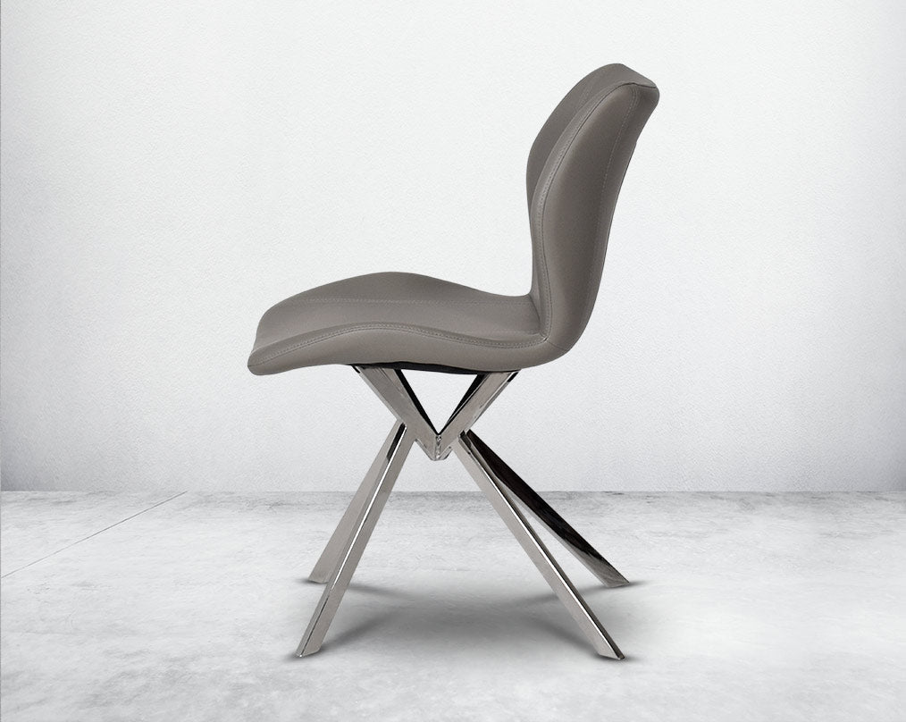 Dining chair upholstered in faux leather with stainless steel legs.