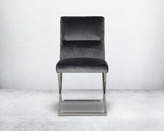 Dining chair  with front upholstered in fabric with high polished stainless steel legs in a cross design.