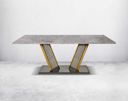 This glorious grey marble top dining table features a tree bark design motif and is crafted with a glossy gold-plated fluted stainless steel base.