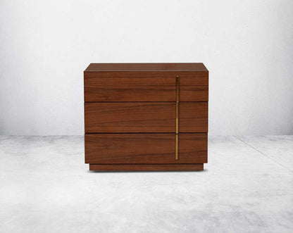 Symmetry and style define this eye-catching bedside table, constructed from light walnut veneer with three drawers & gold-finished stainless steel handles.
