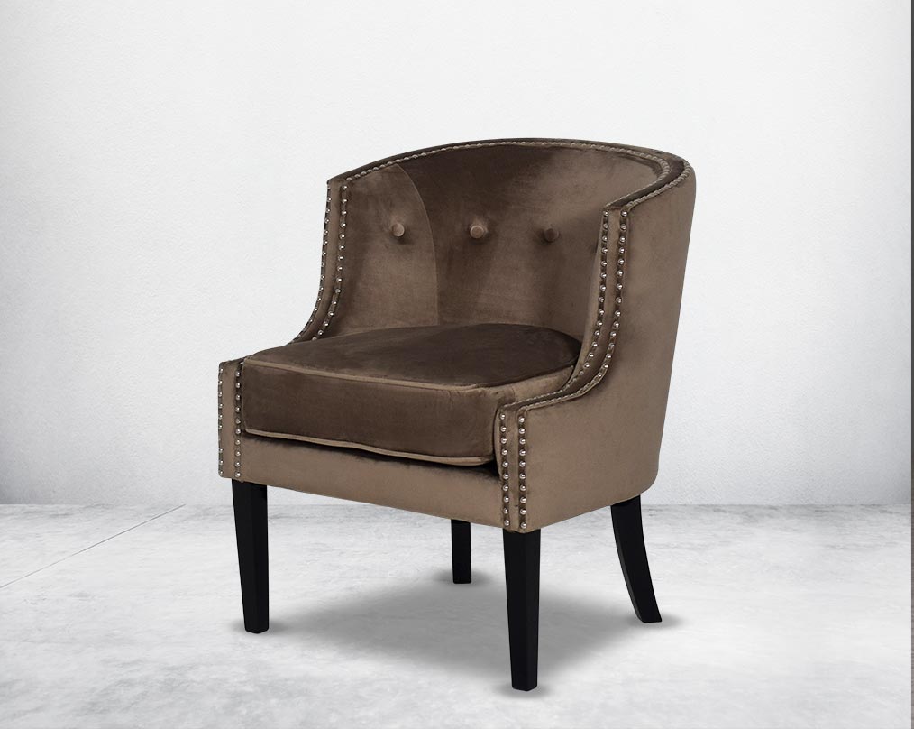 Wing arm chair upholstered in velvet fabric and tufted with steel rivets and legs in brown oak.
