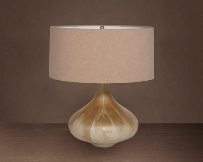 Glass table lamp in Enamel feel with a teardrop-shaped base and translucent beige fabric shade.
