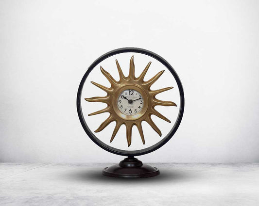 Round table clock in antique matt brass in sun ray design motif.