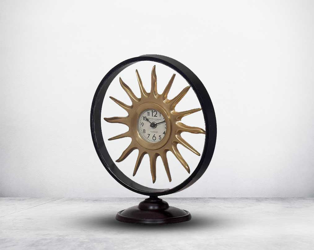 Round table clock in antique matt brass in sun ray design motif.