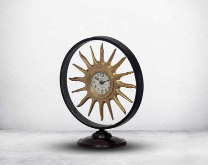 Round table clock in antique matt brass in sun ray design motif.