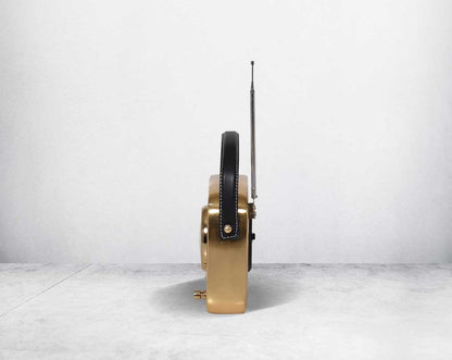 This unique retro table clock is sure to make a statement in any home. It is crafted in antique brass. Has a functional cock in vintage radio design. It has a leather strap hence easy to move around.