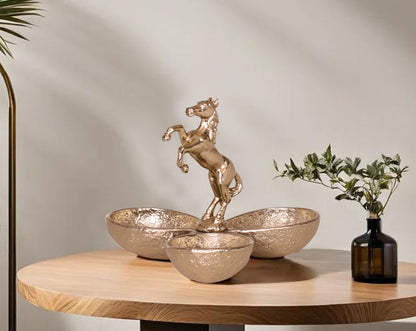 This attractive matt gold-finished aluminium tri bowl with horse handle  with table makes for a perfect serving for any occasion. It features three bowls to have condiments with a swirl handle design for easy handling.