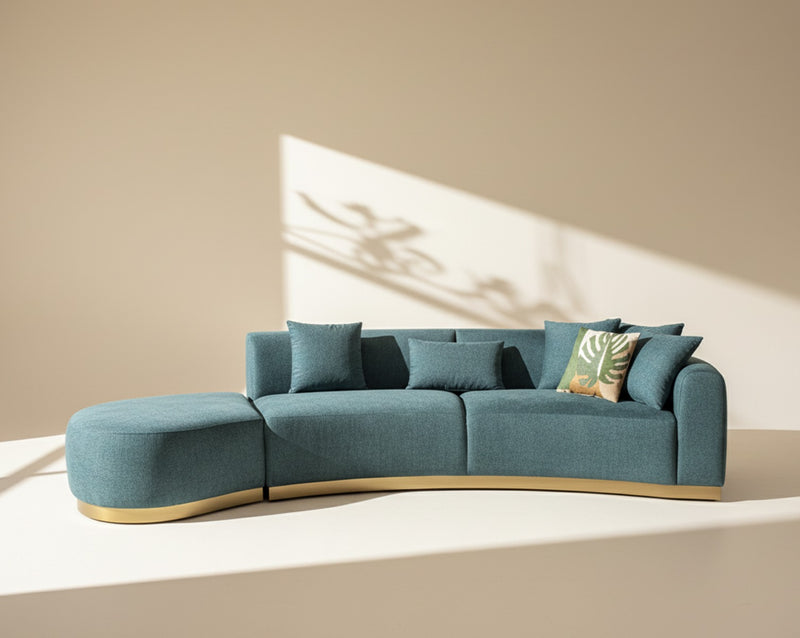 Modern teal sofa with decorative pillows on a beige background