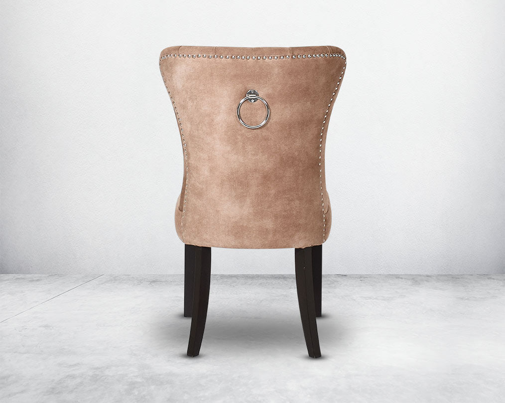 Dining chair upholstered in fabric  back  with tufted back and birchwood legs. Stainless steel decorative ring at the back with stainless steel rivets on the sides.