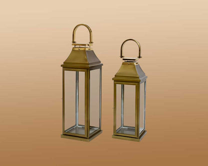 This lantern in modern classic style is crafted in Stainless steel finished in antique gold. It has clear glass & brass handles. This is a perfect mood setter enhancing any room with its glow.