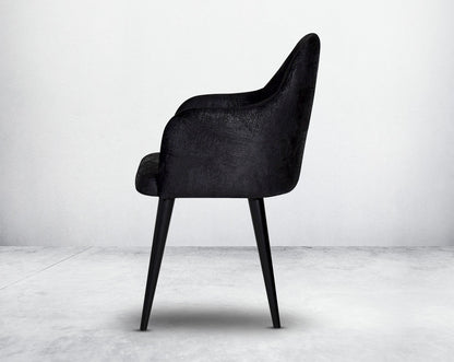 Dining chair upholstered in fabric with side view legs in wood.