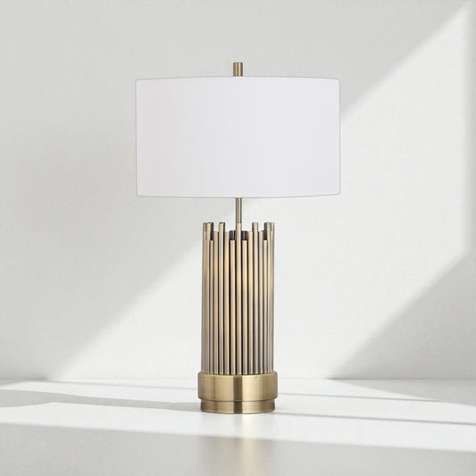 Table lamp with brass base and white shade on a light gray background