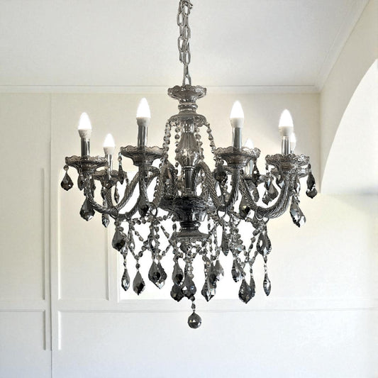 Decorative chandelier hanging in a room with white walls and ceiling.