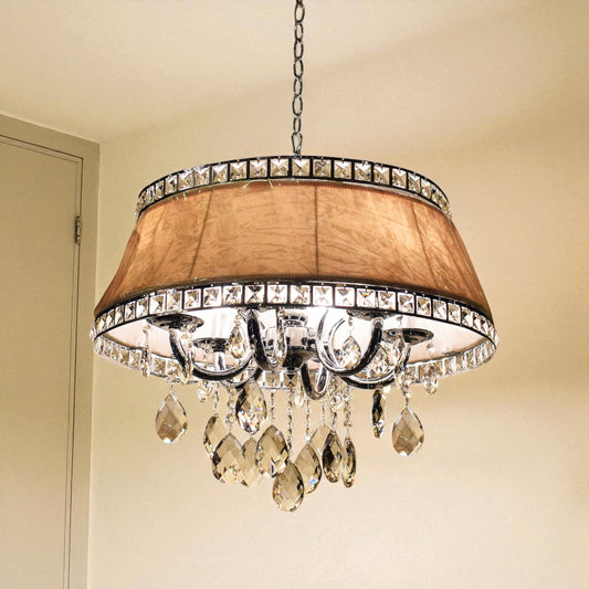 Chandelier with crystal accents and a brown shade on a beige wall.