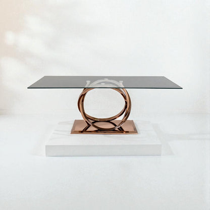 Modern coffee table with a glass top and bronze metal base on a white background