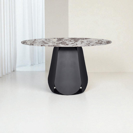 Modern dining table with marble top and black base on a white floor.