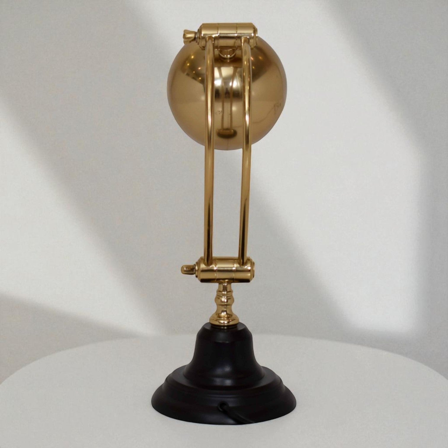 Decorative lamp with gold spherical top and black base on a white background