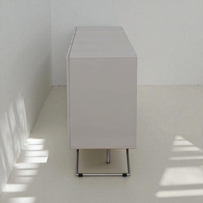 White cabinet against a white wall with sunlight casting shadows on the floor.