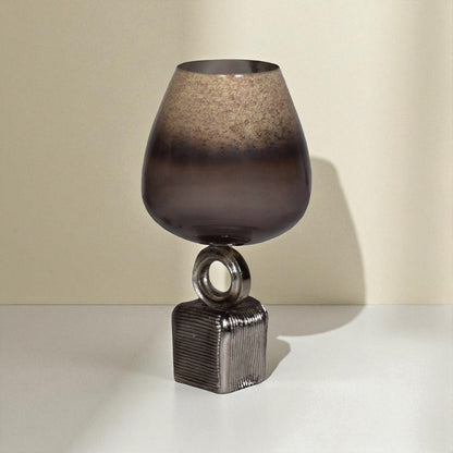 Decorative lamp with a textured glass shade and metallic base on a neutral background