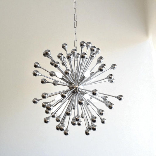 Decorative chandelier with a starburst design on a plain background