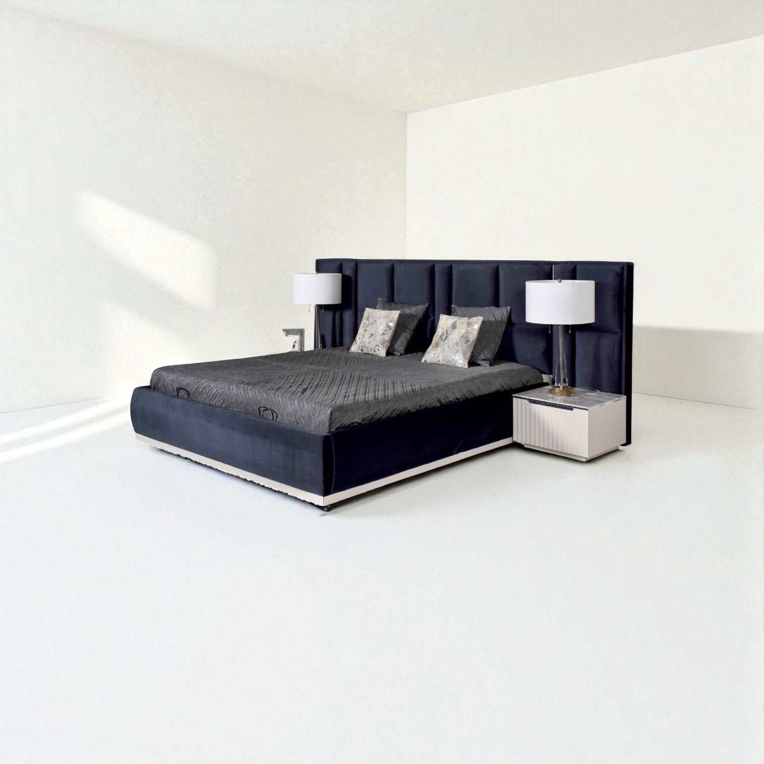 Modern dark blue bed with a tall tufted headboard, gray bedding, decorative pillows, and matching bedside tables with lamps in a minimalist room.