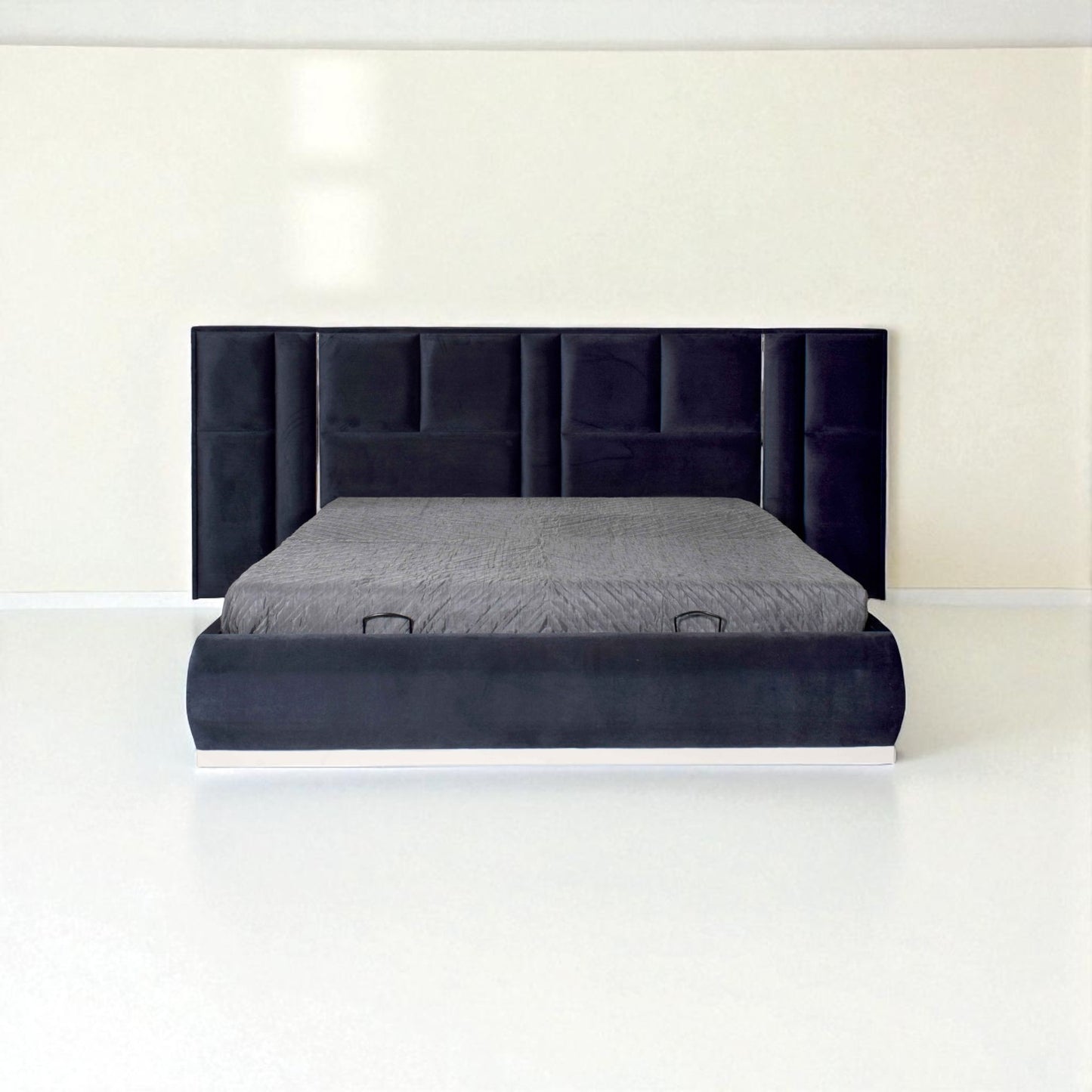 Dark blue upholstered bed with a tall panel headboard and gray bedding in a minimalist white room.