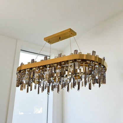 Gold chandelier with crystal accents hanging in a room with a window.