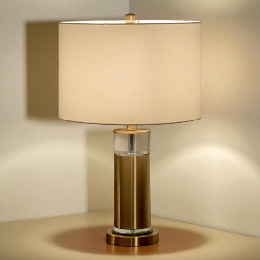 Table lamp with beige shade and bronze base on a neutral background