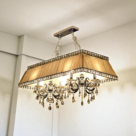 Luxurious chandelier with crystal accents and a gold shade in a room setting.