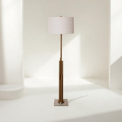 Floor lamp with a white shade and bronze base on a white background