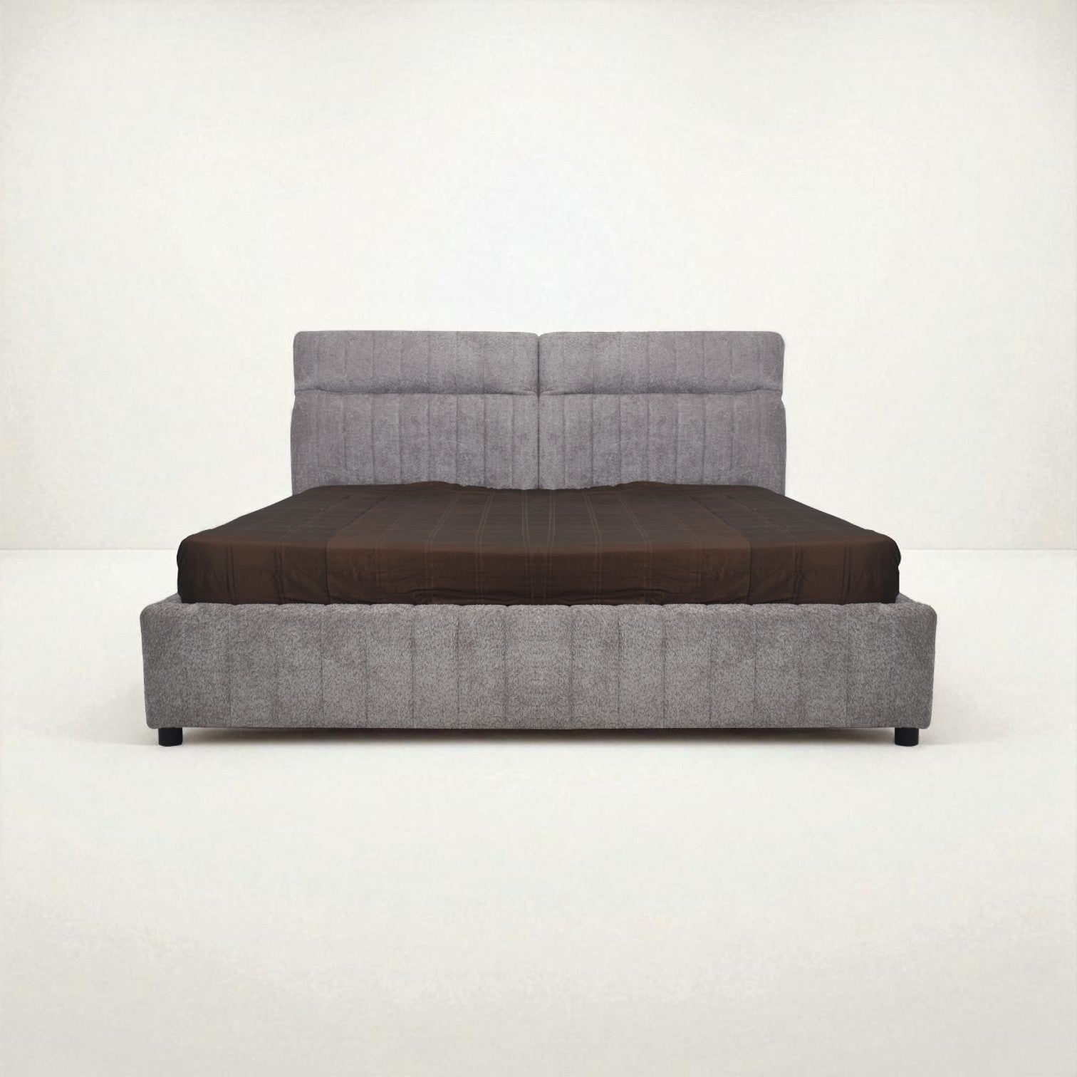 Gray upholstered bed with a brown mattress on a white background