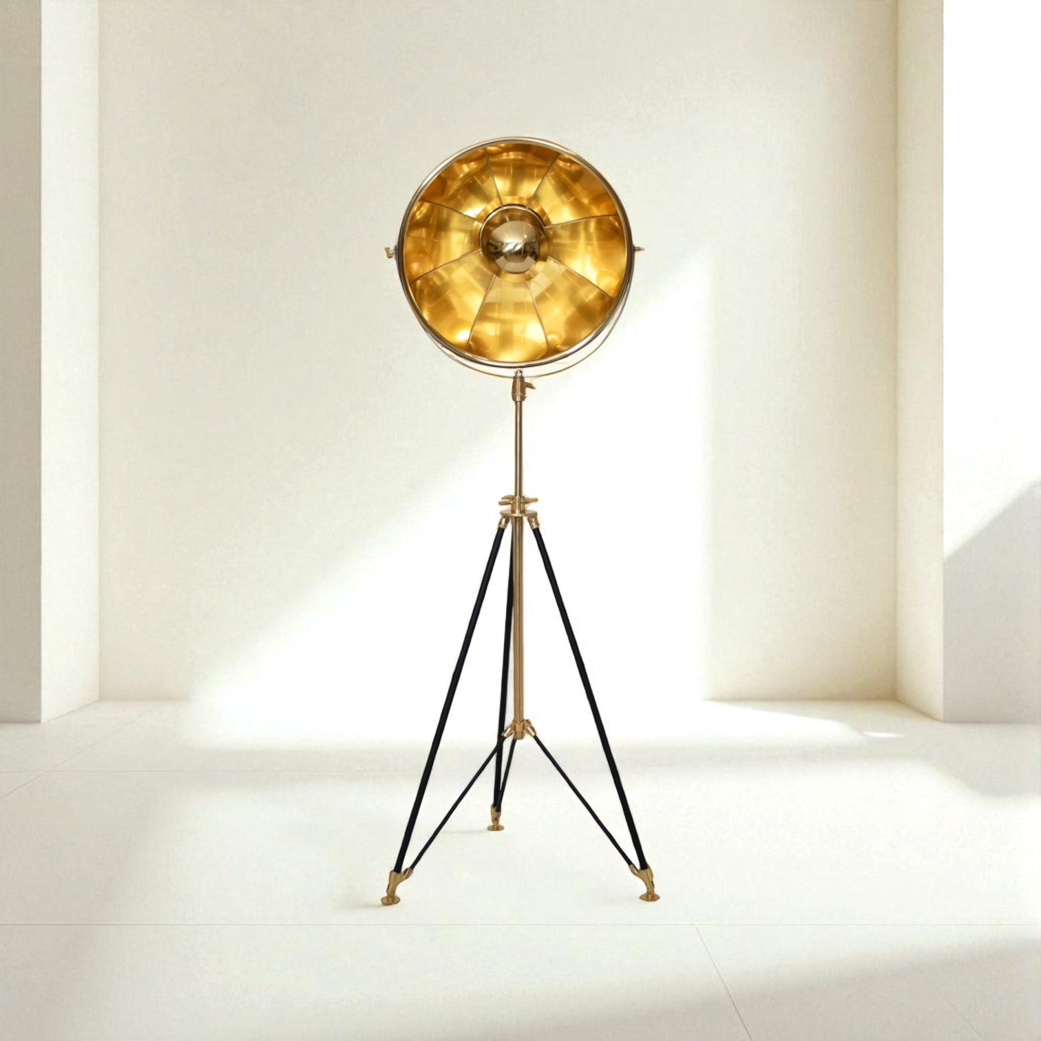 Vintage-style floor lamp with gold shade and black tripod base on a white background