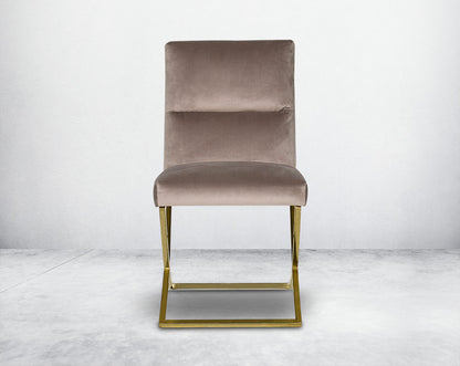 Dining chair with front  upholstered in fabric with gold plated stainless steel legs in a cross design.