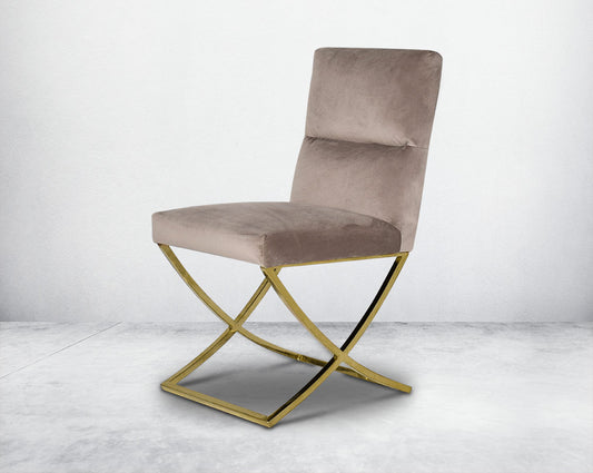 Dining chair upholstered in fabric with gold plated stainless steel legs in a cross design.