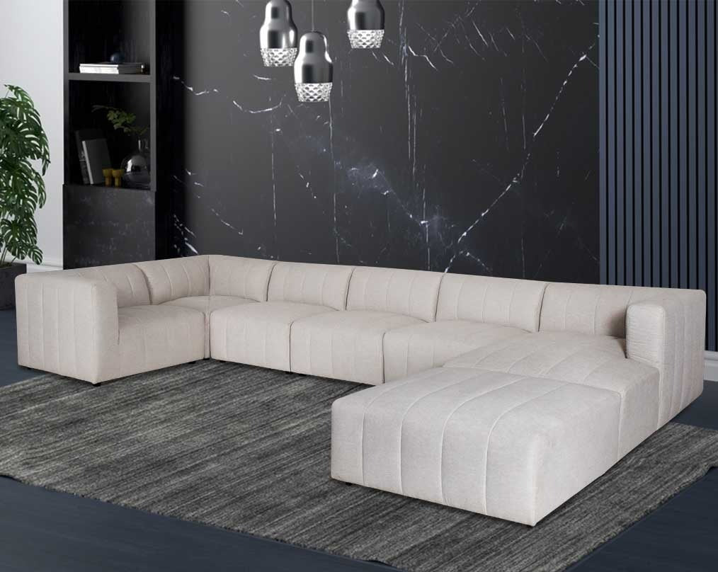 The L shaped modular sofa comes upholstered in regal beige fabric with vertical channel quilting & an ottoman to compliment