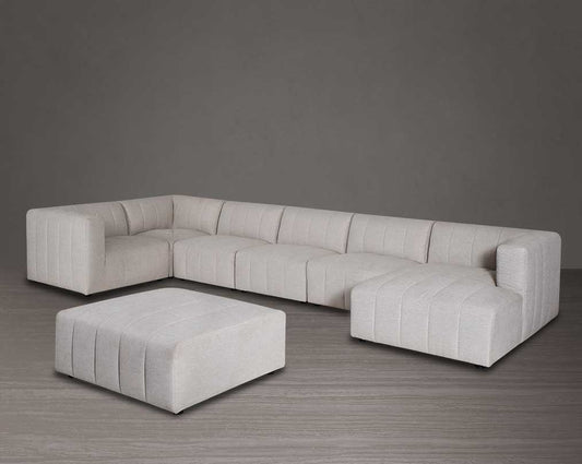 The L shaped modular sofa comes upholstered in regal beige fabric with vertical channel quilting & an ottoman to compliment with table.
