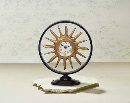 Round table clock in antique matt brass in sun ray design motif.